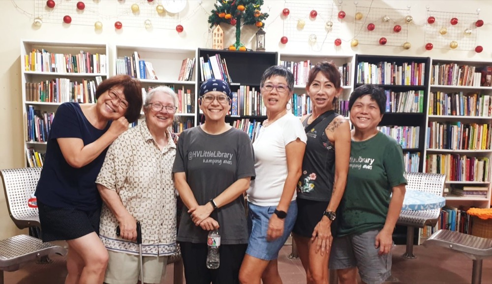 Nadia standing with five Kampong Elves in front of the library shelves